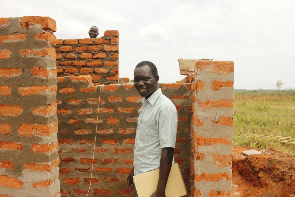 Vincent's story for African Revival showing him smiling whilst checking on the latrine block building progress