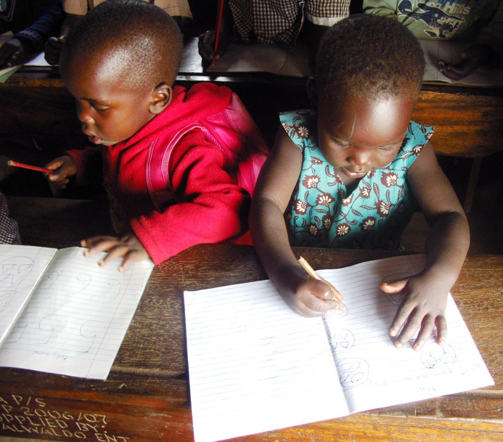 Young children studying on brown desks in an African Revival classroom for school linking programme